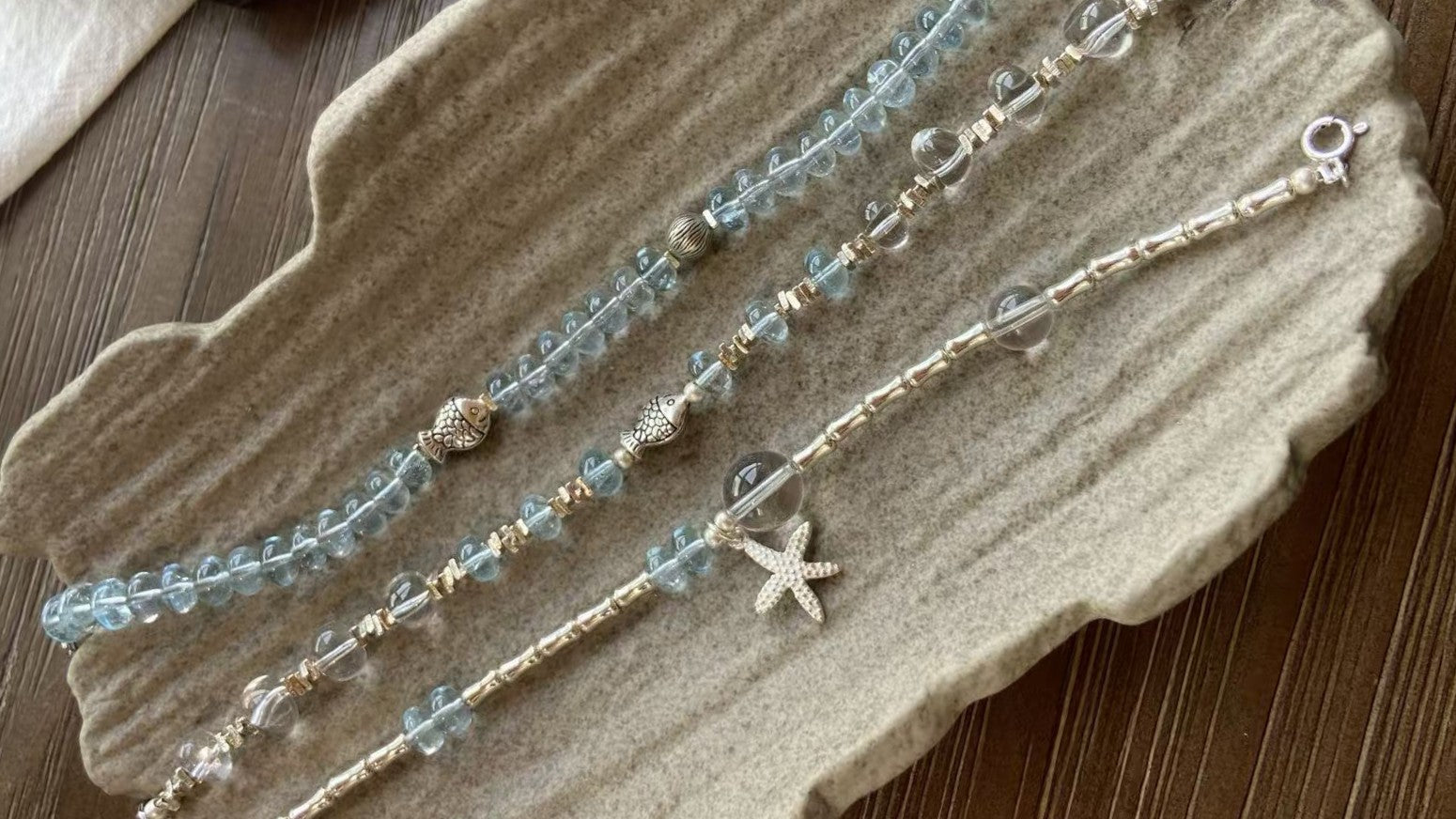 Blue gemstone bracelets styled together on a textured neutral surface