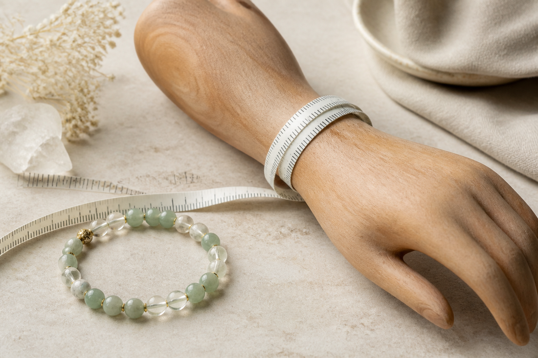 Flexible measuring tape on a wooden hand form beside a natural gemstone bracelet for wrist sizing