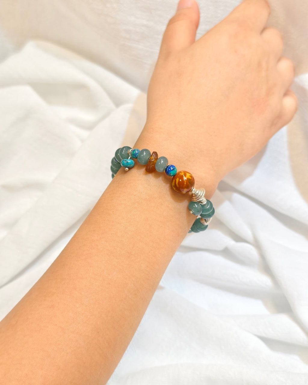 Teal blue gemstone style bracelet worn on the wrist