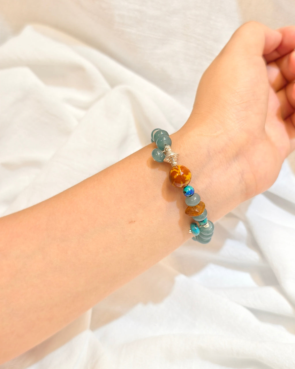 Handmade blue natural stone bracelet with ocean inspired colors worn on wrist