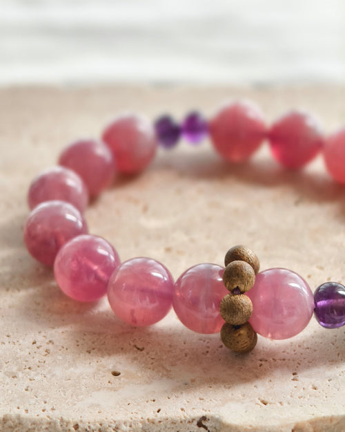 Close-up of pink natural stone beads with purple and gold accent beads