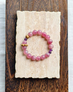 Pink natural stone bracelet styled on handmade paper and wood