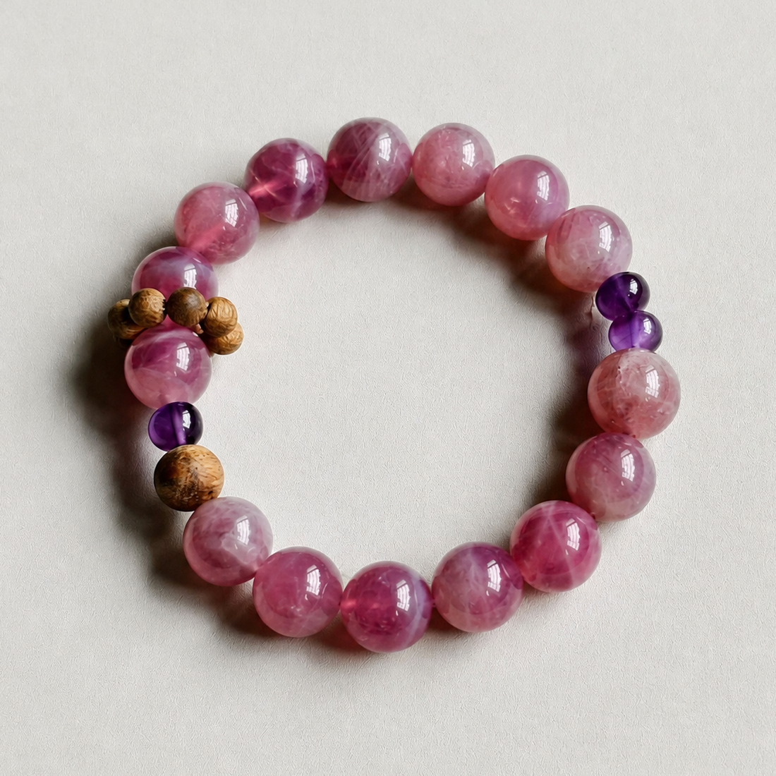 Handmade rose quartz crystal bracelet on a neutral background