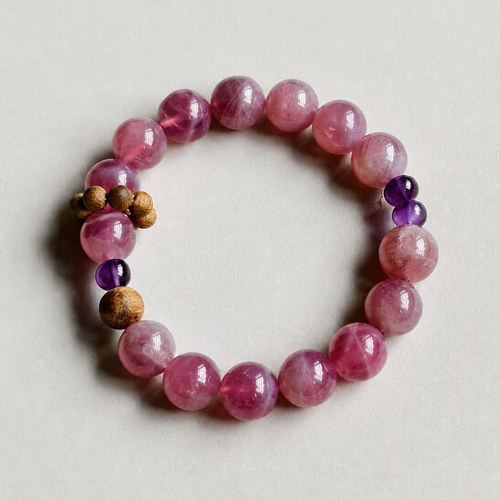 Handmade rose quartz crystal bracelet on a neutral background