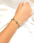 Turquoise tone natural stone bracelet with silver chain details worn on the wrist