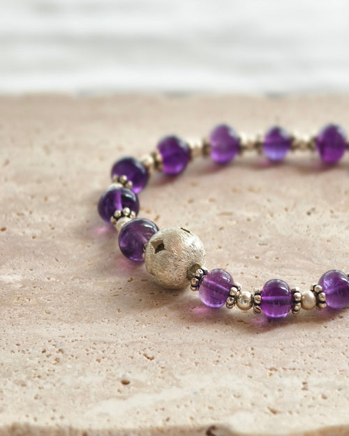 Close-up of purple natural stone beads with crystal and silver accent beads