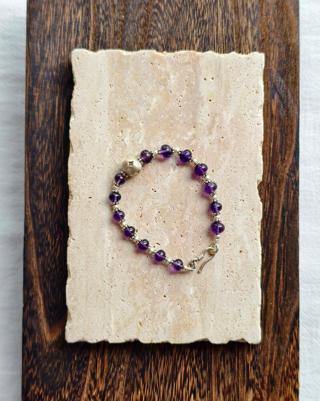 Purple natural stone bracelet styled on handmade paper and wood