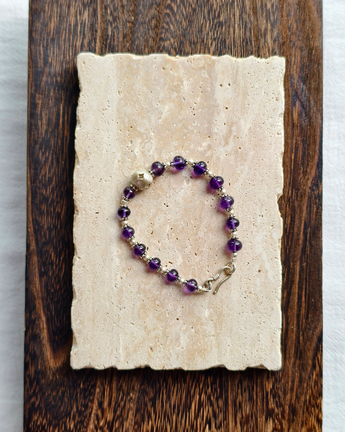 Purple natural stone bracelet styled on handmade paper and wood