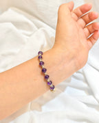 Handmade purple crystal bracelet worn on the wrist in natural light