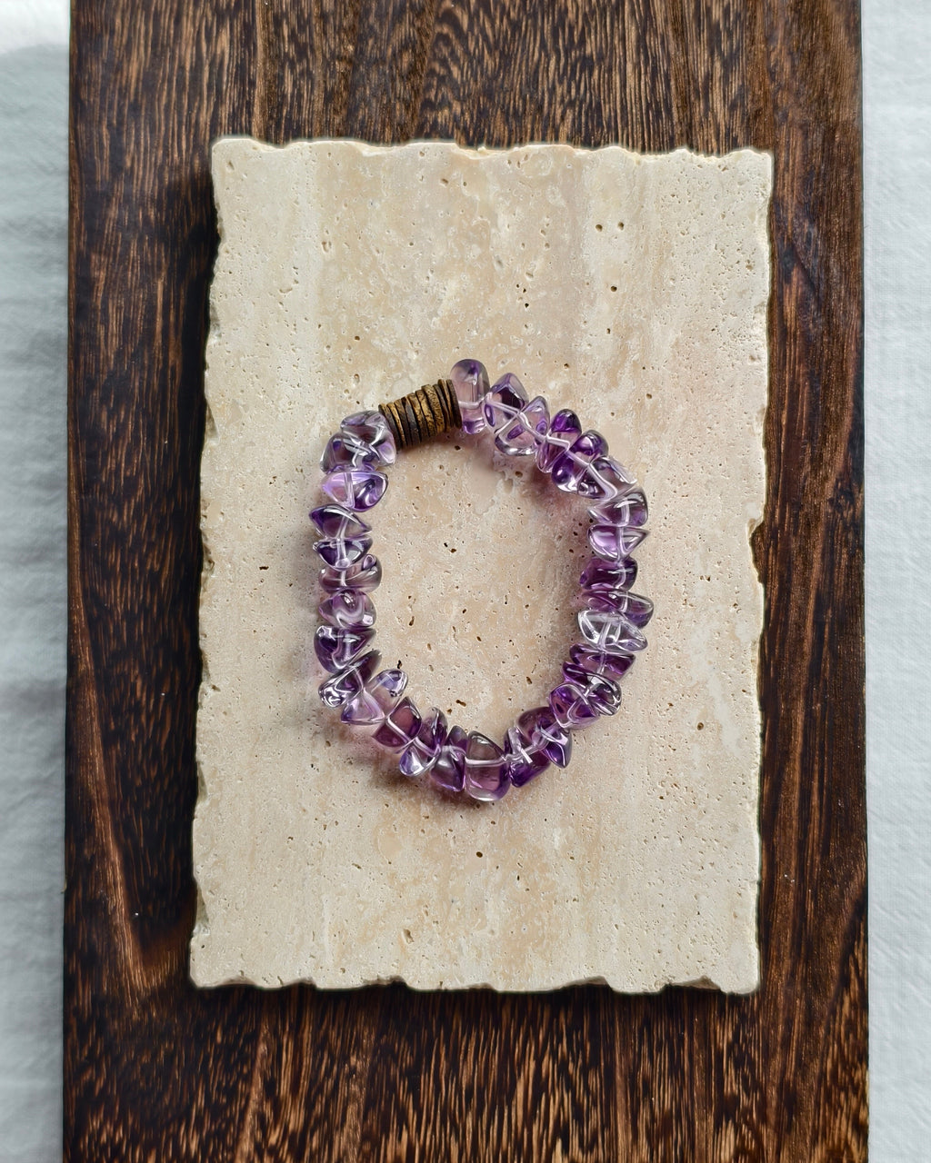 Purple amethyst crystal bracelet styled on handmade paper and wood