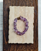 Purple amethyst crystal bracelet styled on handmade paper and wood