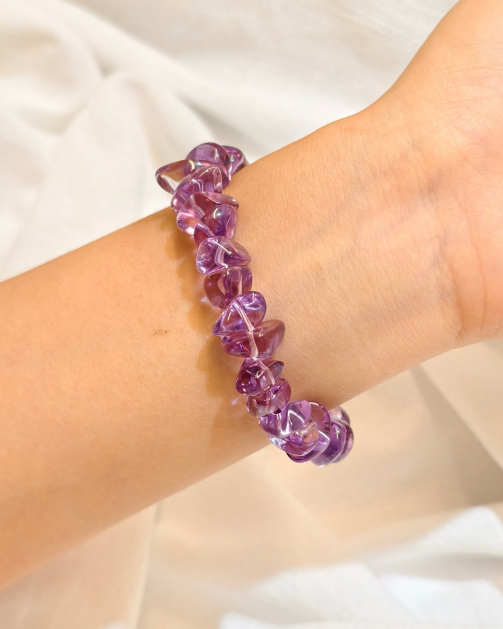 Handmade purple amethyst bracelet worn on the wrist in natural light