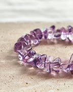 Close-up of purple amethyst crystal beads on a handmade bracelet