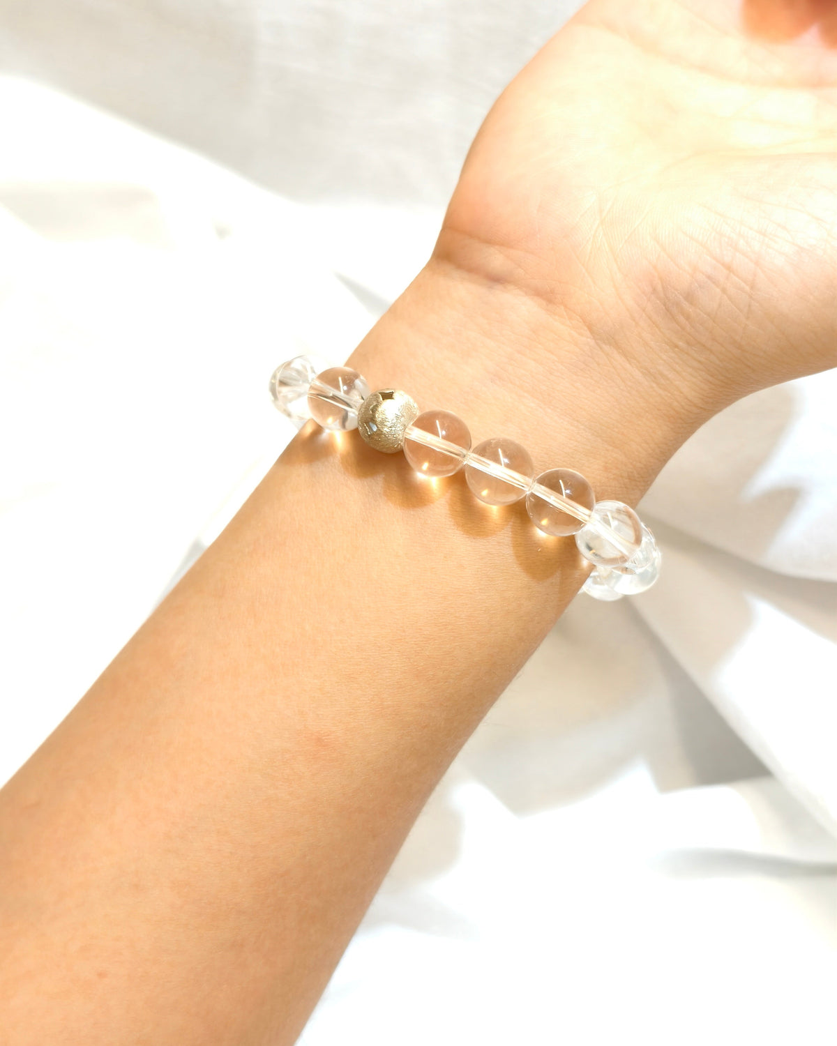 Clear crystal inspired bracelet with blue accent bead worn as handmade jewelry