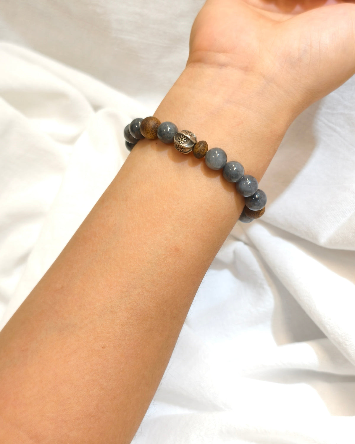 Dark natural stone bracelet with earthy tone beads worn on the wrist