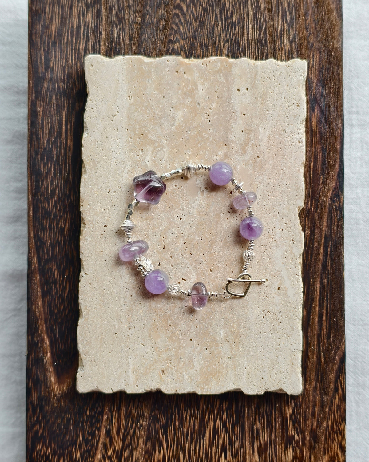 Purple crystal bracelet styled on handmade paper and wooden background