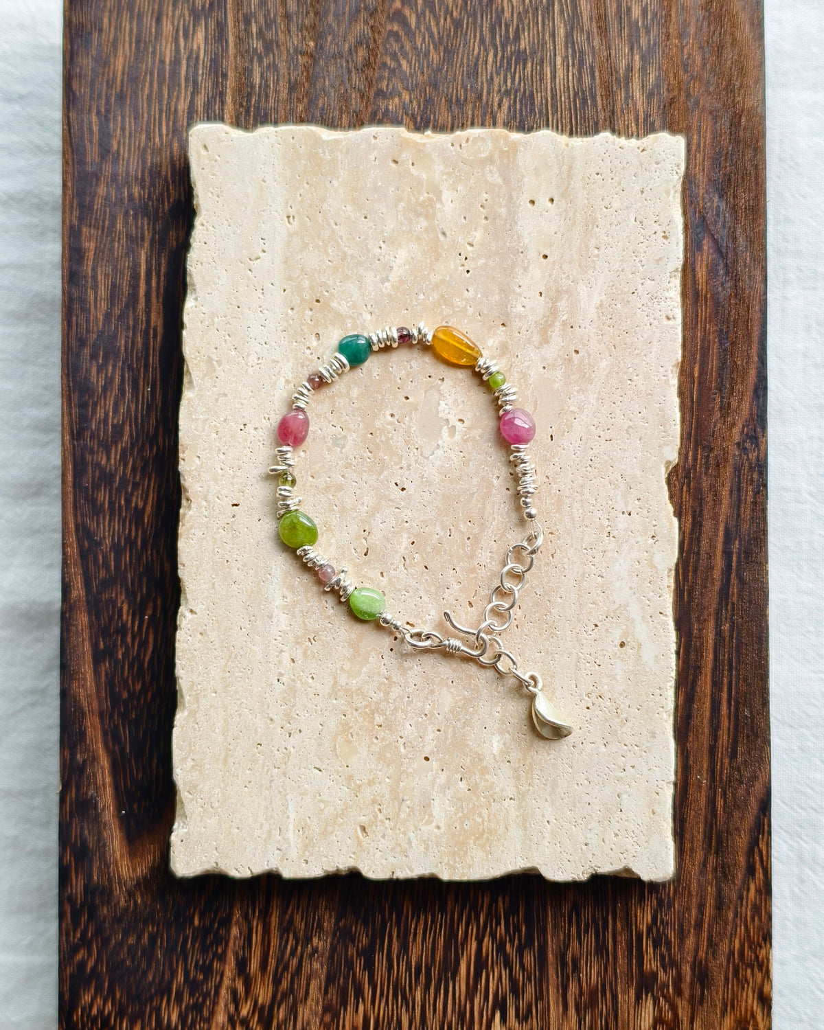 Colorful gemstone bracelet displayed on handmade paper background
